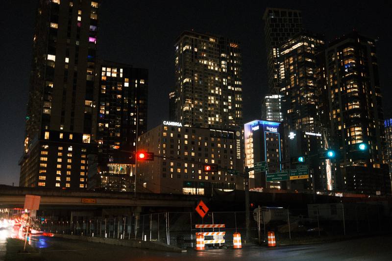 Downtown Austin, Texas skyline at night, towers lit above the highway