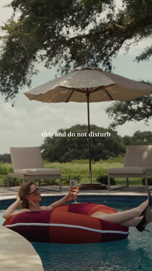 A guest floating in the pool under an umbrella at Stardust Ranch, Texas