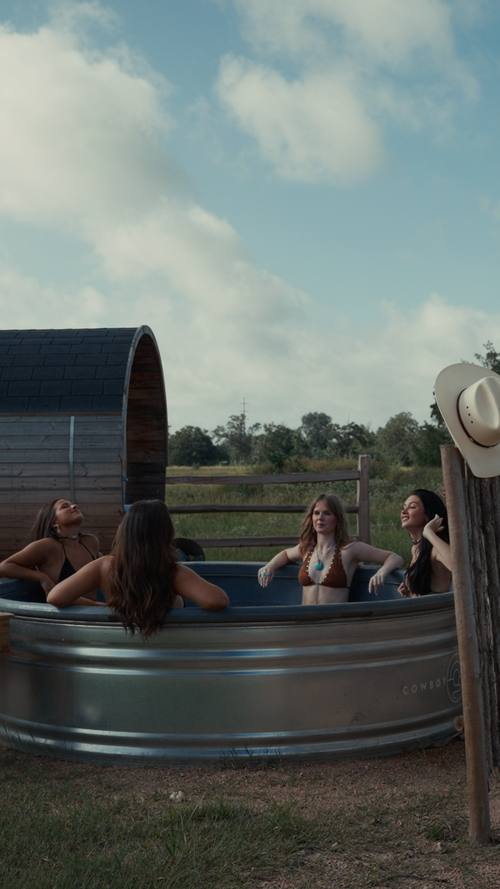 Guests in a stock tank hot tub at Stardust Ranch, Texas, from the wellness morning reel